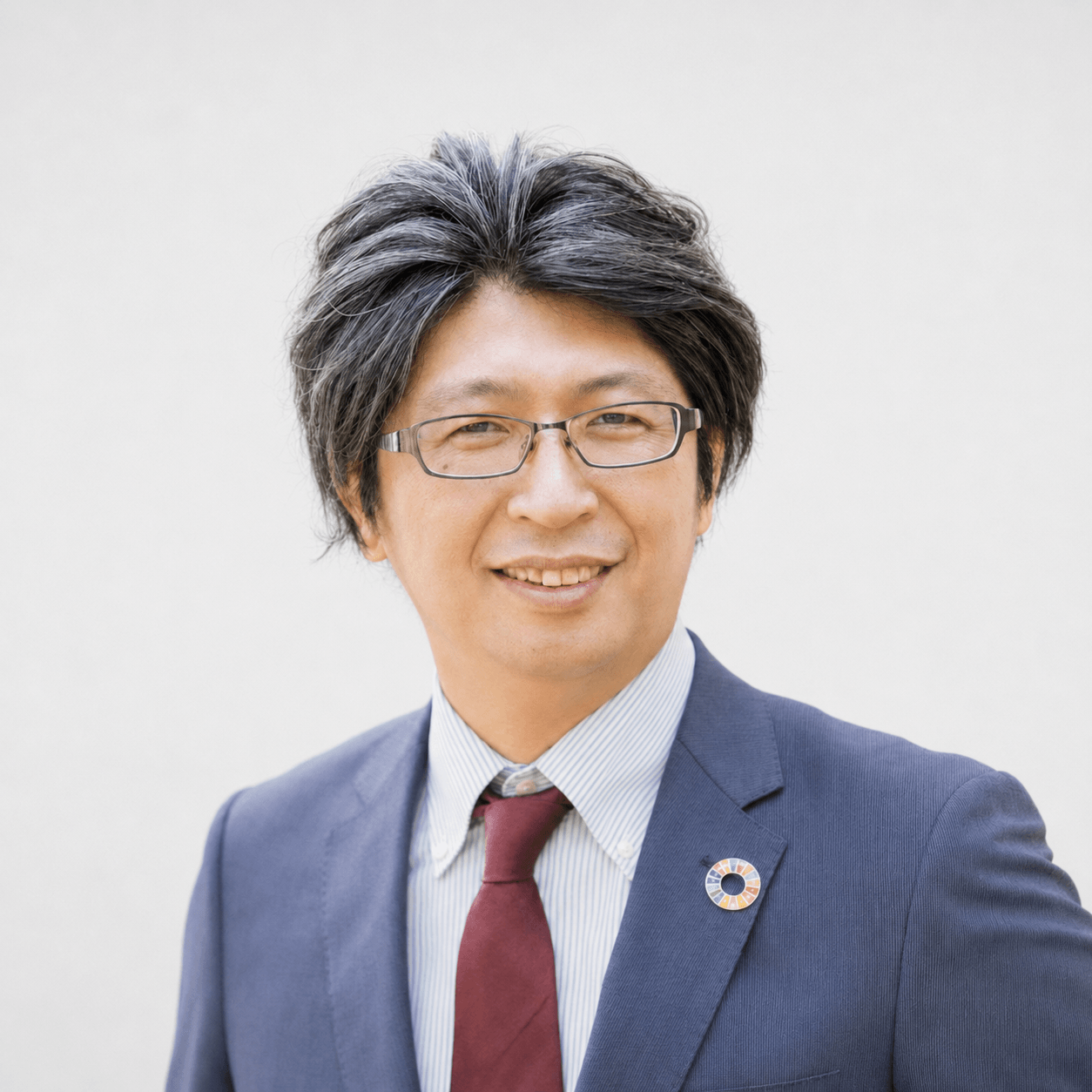 眼鏡をかけたスーツ姿の担当者のプロフィール写真